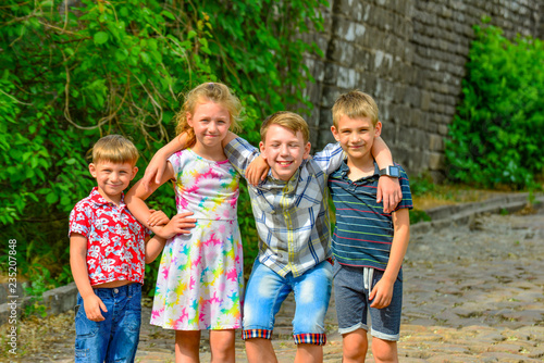 Four happy and joyful children are embracing each other, brothers and sisters together.