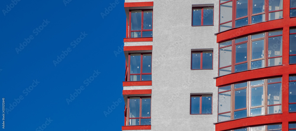Construction site of a new apartment high building against blue sky. Residential area development. Real estate project growth concept Construction site of a new apartment high building against blue sky. Residential area development. Real estate project growth concept