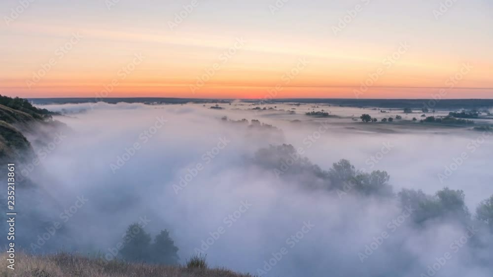 Timelapse mist curling over river and meadow on sunrise background Timelapse mist curling over river and meadow on sunrise background