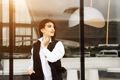 black-haired beautiful girl in a suit and a white shirt posing