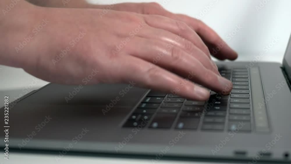 Close up typing on modern notebook computer side view Close up typing on modern notebook computer side view