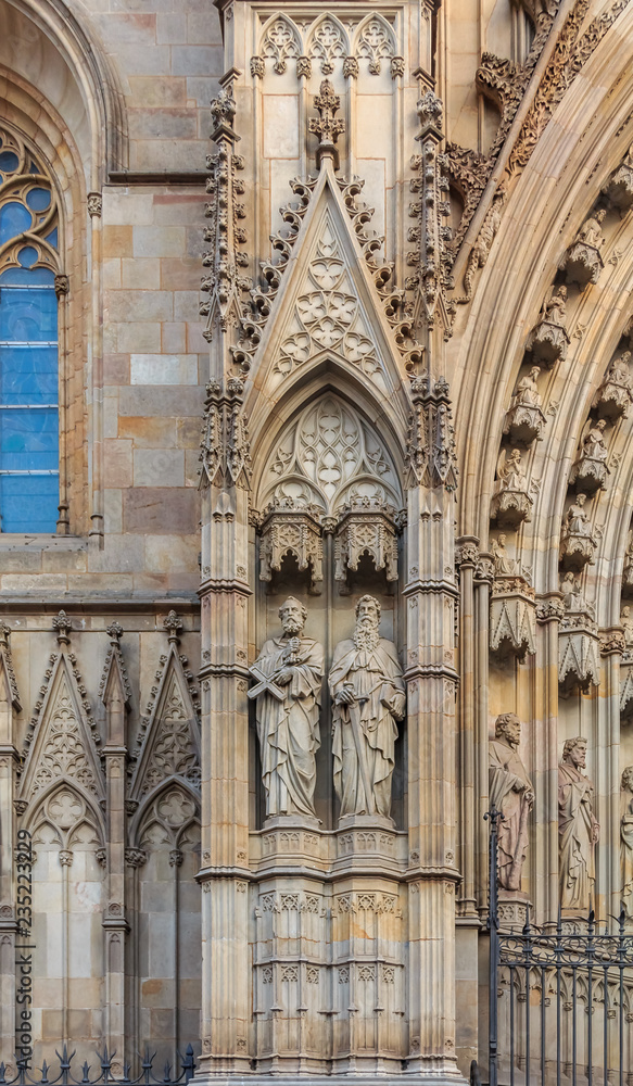 Gothic detail of the sculptures on the facade and tracery of Cathedral of the Holy Cross and Saint Eulalia, or Barcelona Cathedral at sunset in Barcelona, Spain