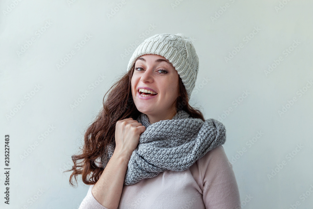 Beautiful woman winter portrait, true emotions. Laughing girl with long hair wearing warm clothes hat scarf isolated on white background. Young hipster girl looking happy and excited, having fun