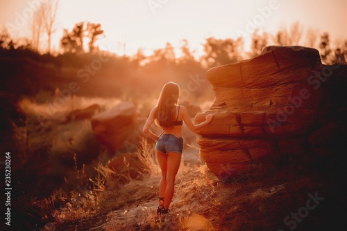 Beautiful girl in shorts in a sand quarry.