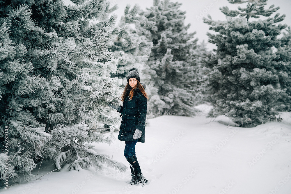 Beautiful red-haired girl in the winter forest.