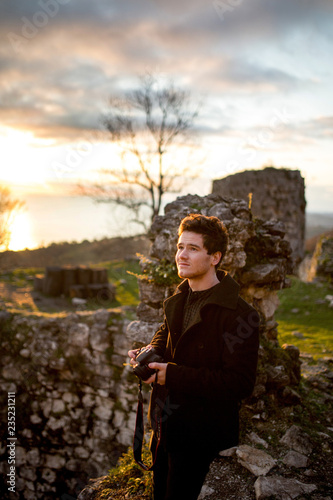 portrait of young man in black. casle and sky background photo