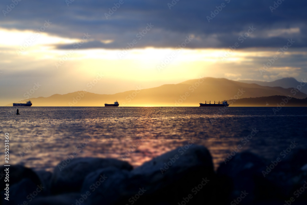 Cargo Ships in the Sunset off a coastline beach of Vancouver, British Columbia