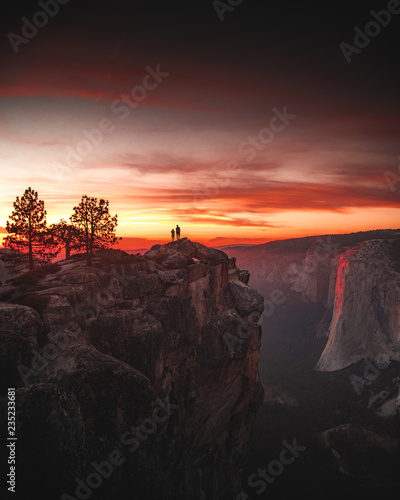 2 people standing on cliff sunset © Abraham