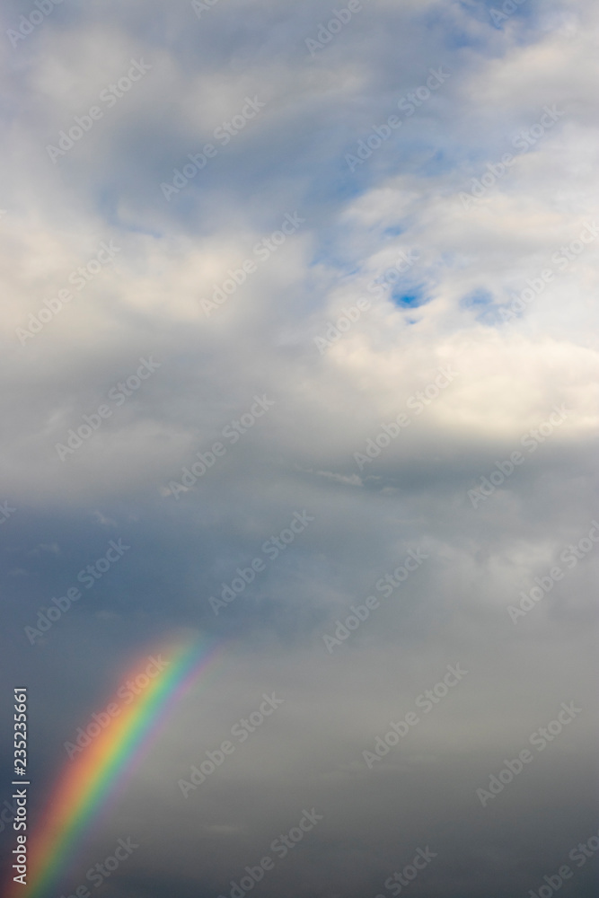 Rainbow on a cloudy sky background