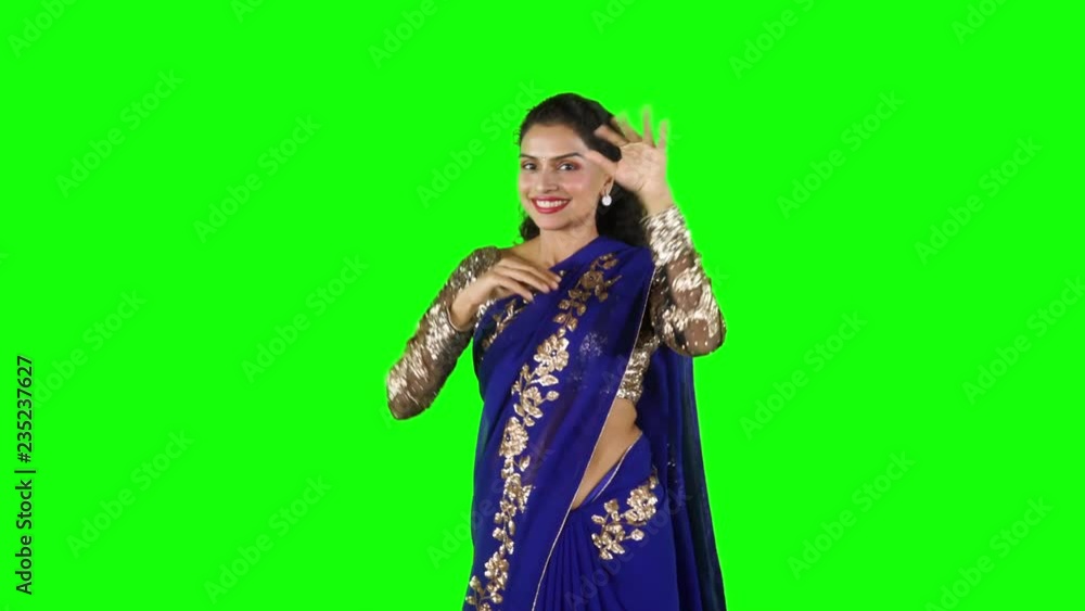 Pretty Indian woman wearing sari clothes and dancing in the studio while smiling and looking at camera. Shot in 4k resolution with green screen background Pretty Indian woman wearing sari clothes and dancing in the studio while smiling and looking at camera. Shot in 4k resolution with green screen background