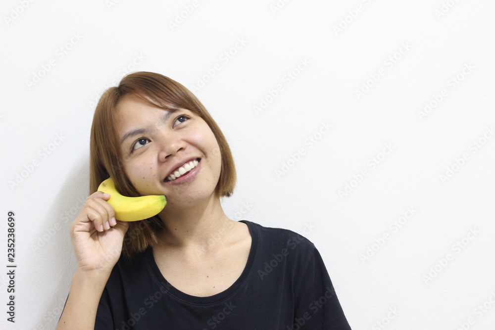young woman posing with banana on white background young woman posing with banana on white background