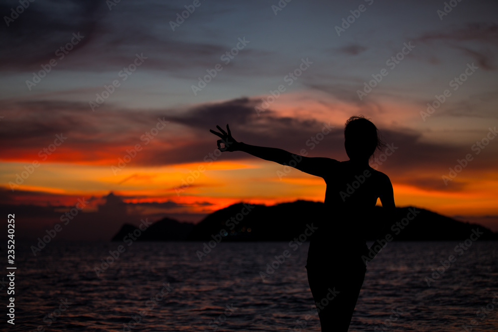 Silhouette of a woman  show Okay sign on sunset background
