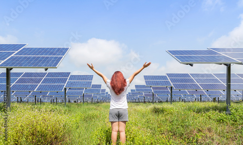 woman standing raised up arms celebrate achievements freedom success in solar cell power station.  Ecology concept.    photo