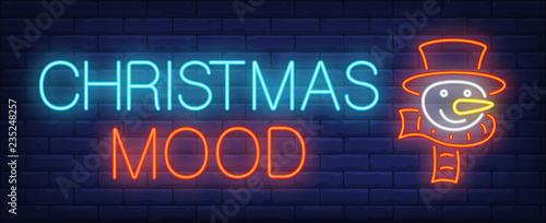 Christmas mood neon sign. Glowing inscription with snowman in cylinder hat and scarf on brick wall background. Can be used for christmas, winter, advertisement