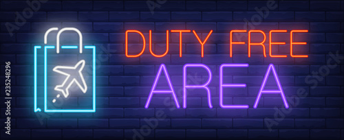 Duty free area neon sign. Glowing inscription with paper bags with plane illustration on brick wall background. Can be used for shopping, duty free, airport