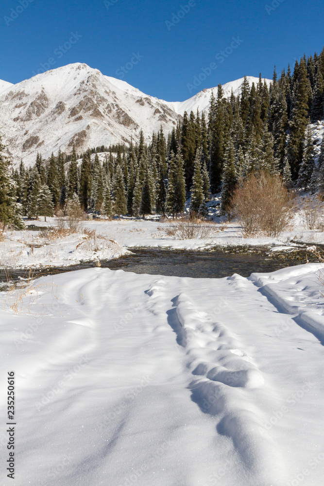 snowy road through a creek in the mountains snowy road through a creek in the mountains