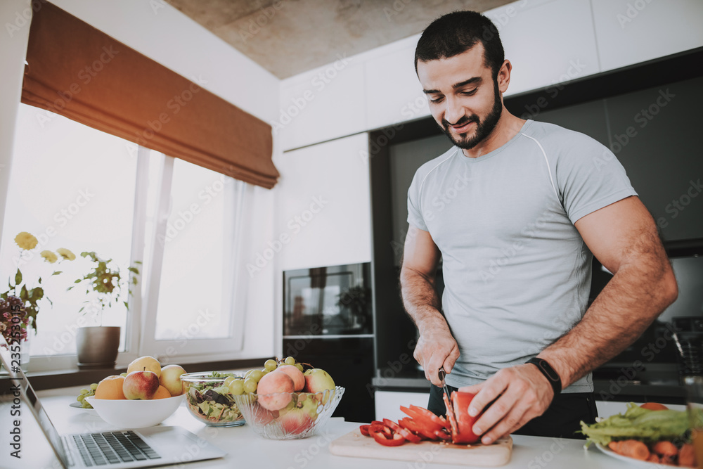 Athletic Man Stands In Kitchen. Cooking Concept. Athletic Man Stands In Kitchen. Cooking Concept.
