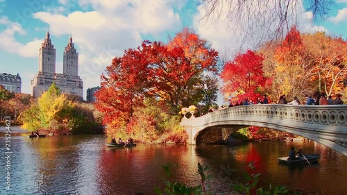 New York City Central Park in Autumn with skyscrapers apartment bridge boat and lake photo