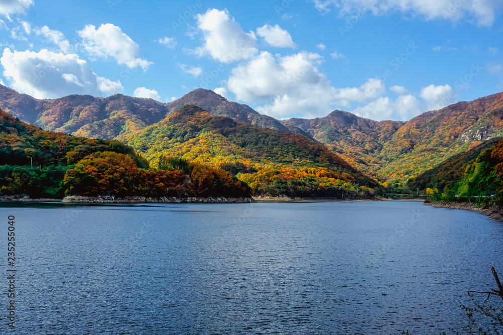 Beautiful mountain lake in the valley of the hills, in autumn, among thousands of colorful trees. Iwon Village, South Korea