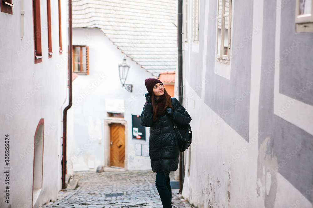 Tourist girl on a beautiful street in Cesky Krumlov in the Czech Republic while traveling around the city is looking at sightseeing places or she is lost. Tourist girl on a beautiful street in Cesky Krumlov in the Czech Republic while traveling around the city is looking at sightseeing places or she is lost.