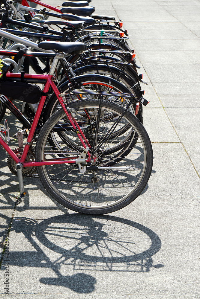  row of bikes parked at a bicycle stand or rack                              