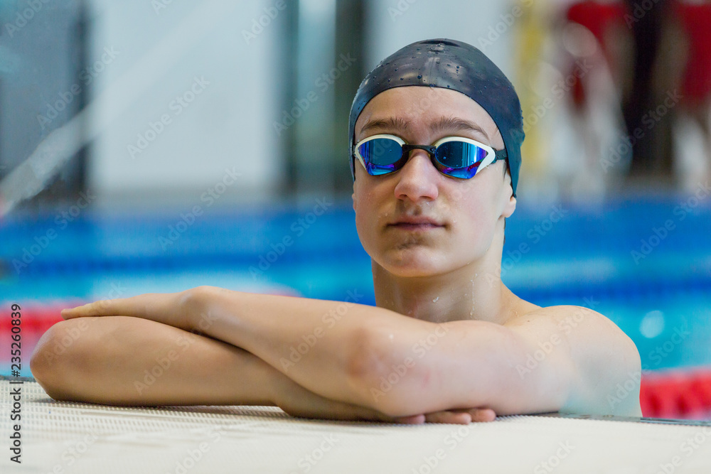 Portrait of athletic teenage boy at the sports pool. Close up, copy space.