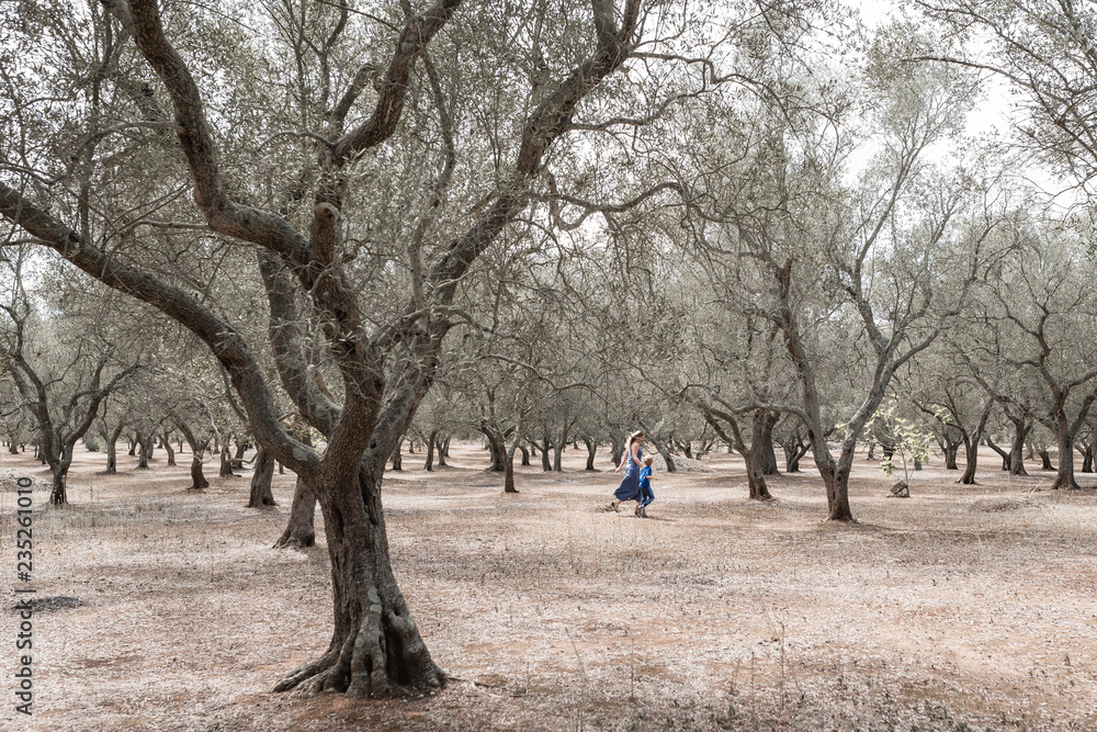 Mom and son running in olive grove