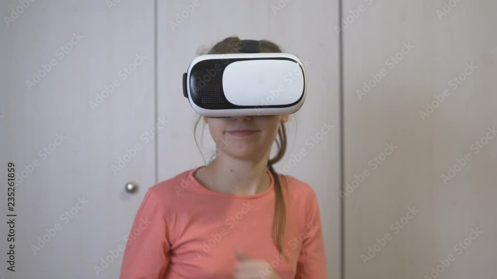 Teen girl wears her virtual reality headset and joyfully virtual world.
Teen girl wears her virtual reality headset and joyfully virtual world.