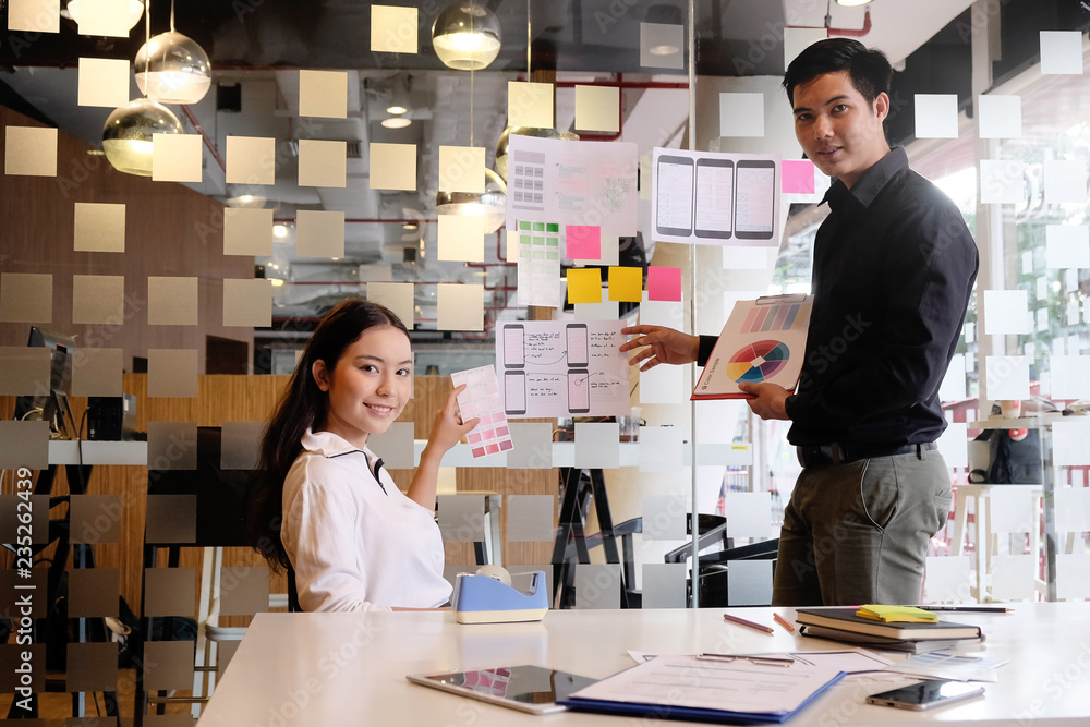 Obraz premium Team working with software development creative and using stocky note paper on glass wall.