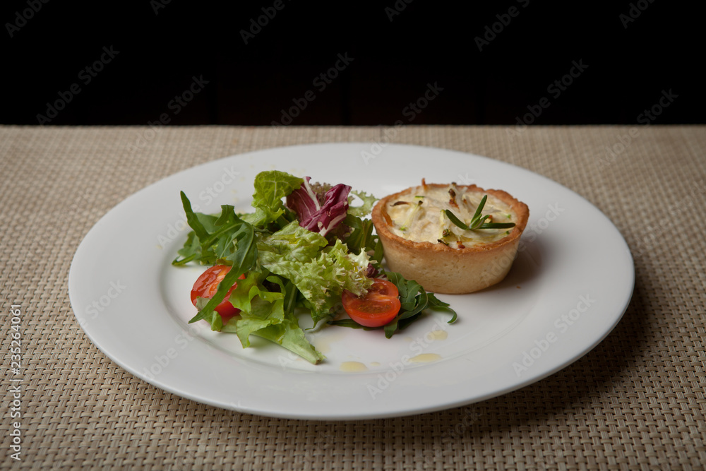 julienne in tartlet with salad and tomatoes on a white plate julienne in tartlet with salad and tomatoes on a white plate