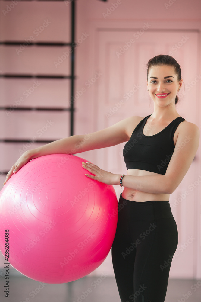 Young woman training in the gym with fitball. Personal trainer indoors workout. Exercises with fit ball. Young woman training in the gym with fitball. Personal trainer indoors workout. Exercises with fit ball.