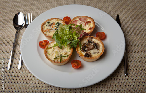 julienne in tartlet with salad and tomatoes on a white plate