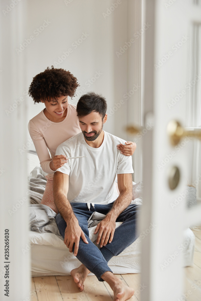 Happy black woman shows pregnancy test to husband, satisfied with positive result, pose in bedroom of modern flat, rejoice good news, ready to become parents. Family couple indoor. Parenthood Happy black woman shows pregnancy test to husband, satisfied with positive result, pose in bedroom of modern flat, rejoice good news, ready to become parents. Family couple indoor. Parenthood