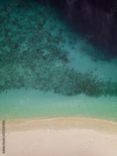 An aerial view of a croal reef falling into the deep blue water in Gili Meno in Indonesia photo