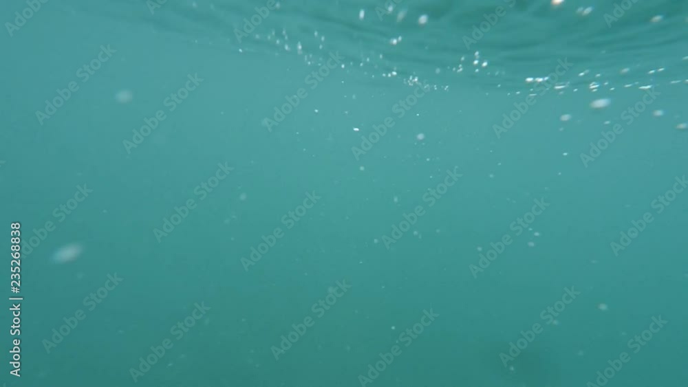 Male hand try to show thumb up sign gesture on blue underwater background with bubbles. Gestures and signs. Body language on blue sea water background Closeup POV Point of view Male hand try to show thumb up sign gesture on blue underwater background with bubbles. Gestures and signs. Body language on blue sea water background Closeup POV Point of view