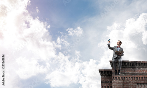 Wallpaper Mural Young businessman or student studying the science on building roof Torontodigital.ca