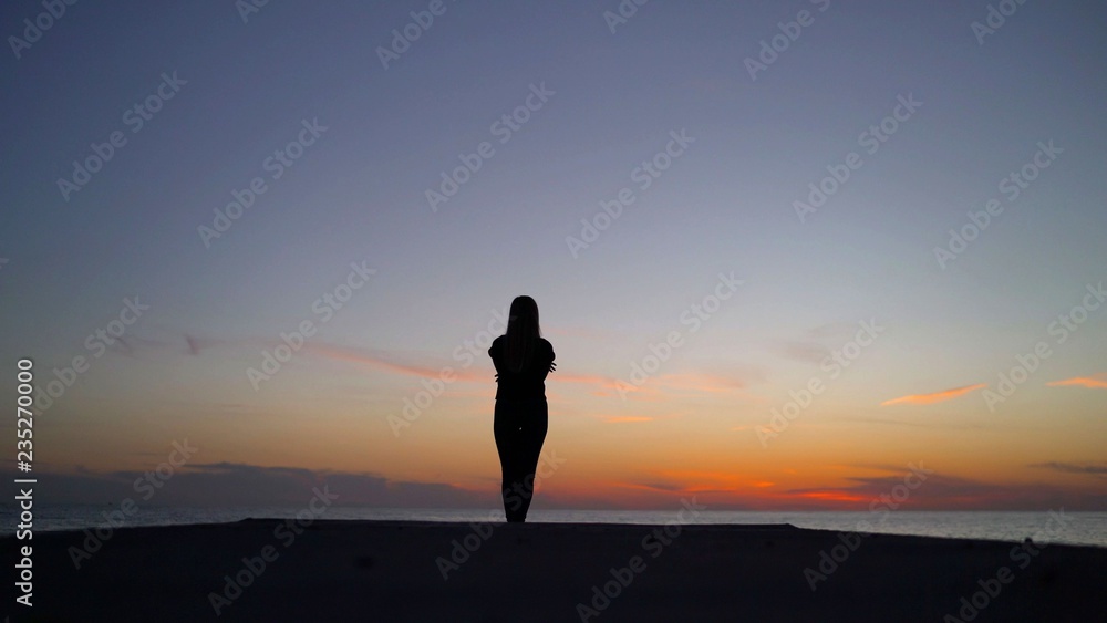 Beautiful girl on the sunset background. Girl at sunset by the sea.