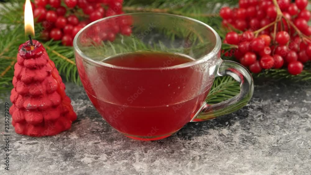 Winter still life with hot tea with viburnum berries, branch of pine and burning candle on the surface with hoarfrost Winter still life with hot tea with viburnum berries, branch of pine and burning candle on the surface with hoarfrost