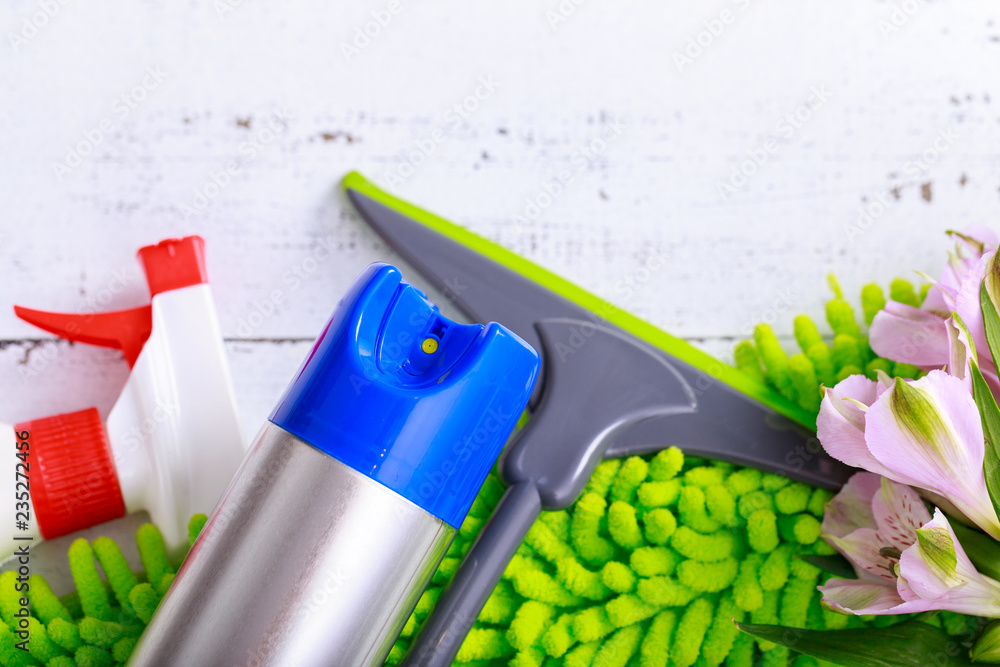 Spring cleaning concept. Cleaning supplies on wood background.