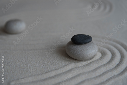 Gray zen stones on the sand with wave drawings. Concept of harmony  balance and meditation  spa  massage  relax