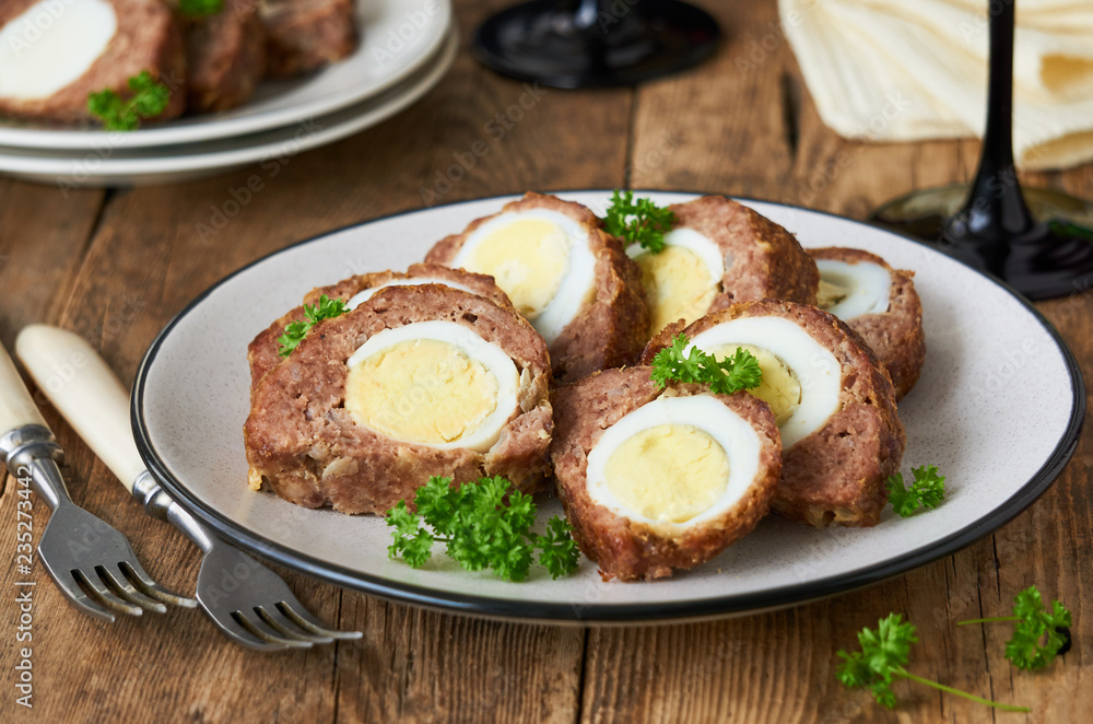 Slices of meatloaf with boiled eggs on a plate      