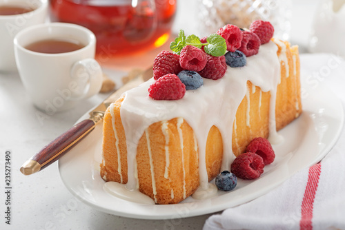 Butter vanilla cake for breakfast with glaze and fresh berries.