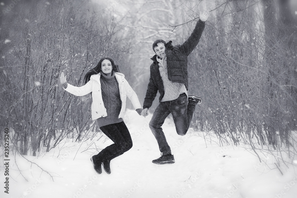 A loving couple on a winter walk. Man and woman on a date in the park in winter. Friends in a winter park A loving couple on a winter walk. Man and woman on a date in the park in winter. Friends in a winter park