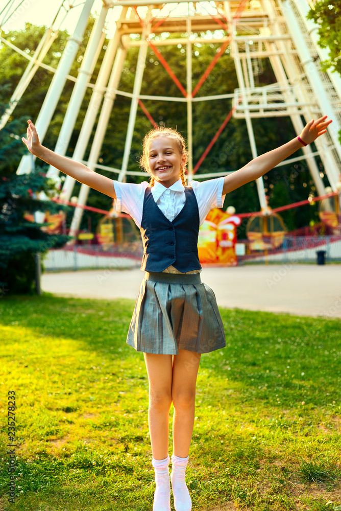 schoolgirl joyful smiling and jumping raising hands up.