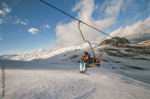 Snowboarder climbing up the hill photo