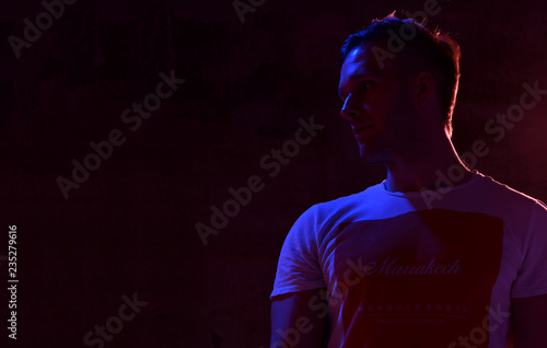 Neon light portrait of sexy man muscular body and white t-shirt looking up