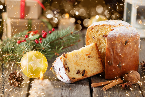 Traditional Italian Christmas fruit cake Panettone with Christmas decorations, gift box and mulled wine, on wooden home background, copy space.