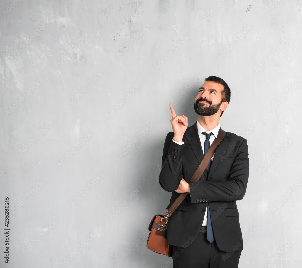 Businessman with beard pointing a great idea and looking up Businessman with beard pointing a great idea and looking up