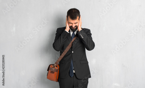 Businessman with beard covering both ears with hands photo