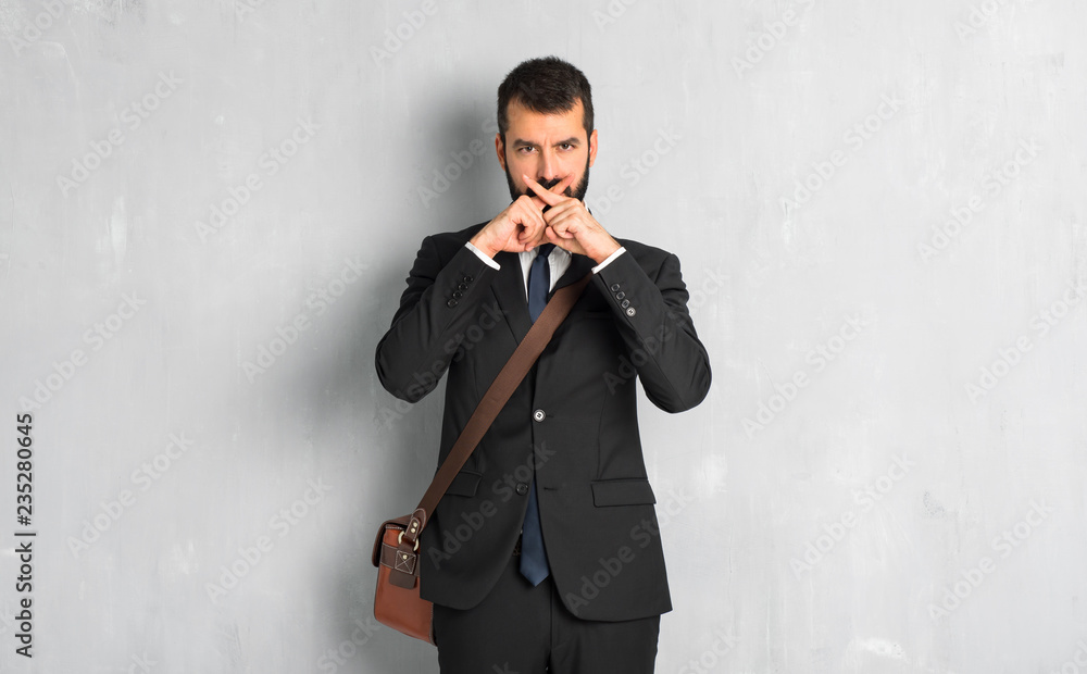 Businessman with beard showing a sign of silence gesture Businessman with beard showing a sign of silence gesture
